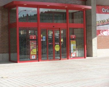 Puerta automática instalada para local con fachada roja Puerta automática instalada para local con fachada roja