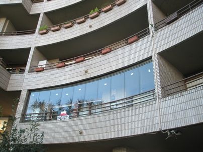 Instalación de una cortina de cristal en una terraza de un bloque de edificios Instalación de una cortina de cristal en una terraza de un bloque de edificios