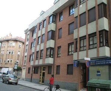 Vista desde la calle de un bloque de viviendas con ventanas metálicas