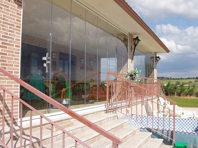 Cortina de cristal en un chalet con jardín vista desde el jardín Cortina de cristal en un chalet con jardín vista desde el jardín